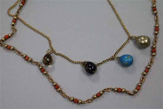 A 9ct gold necklace hung with four egg shaped charms and a 9ct gold and coral bead necklace.